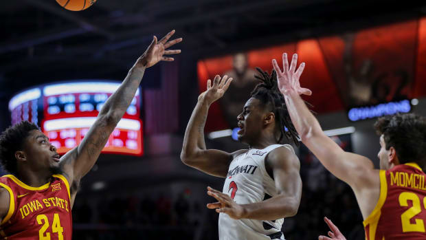  Feb 13, 2024; Cincinnati, Ohio, USA; Cincinnati Bearcats guard Jizzle James (2) passes the ball against Iowa State Cyclones forward Hason Ward (24) and forward Milan Momcilovic (22) in the second half at Fifth Third Arena. Mandatory Credit: Katie Stratman-USA TODAY Sports